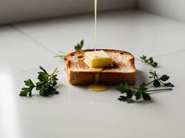 A slice of bread with butter being drizzled on top photo