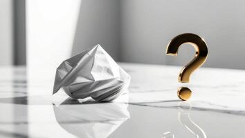 A gold question mark on a white marble table with a crumpled paper photo