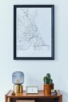 Stylish scandinavian living room interior with retro commode, black mock up poster frame, clock, cacti, book, table lamp and personal accessoreis in home decor. Template photo
