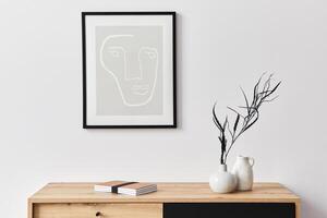 Stylish interior of living room with mock up poster frame, wooden commode, book, leaf in ceramic vase and elegant accessories. Minimalist concept of home decor. photo