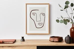 Stylish interior of living room with mock up poster frame, wooden commode, book, eucalyptus leaf in ceramic vase and elegant accessories. Minimalist concept of home decor. photo