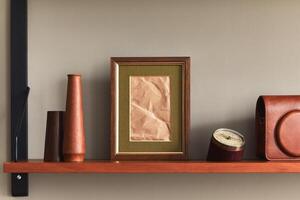 Minimalist composition on wooden shelf with brown mock up picture frame, clock, vase, camera case and elegant personal accessories in stylish home decor photo