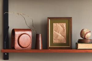 Minimalist composition on wooden shelf with brown mock up picture frame, clock, vase, camera case and elegant personal accessories in stylish home decor. photo