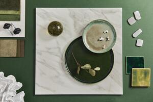 Stylish flat lay composition of creative architect moodboard design with samples of building, textile and natural materials and personal accessories. Top view, green background. photo