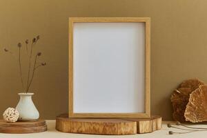 Stylish composition of minimalistic room interior design with mock up poster frame, natural materials as wood, dry plants and personal accessories. Neutral and yellow colors, template. photo