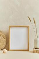 Stylish cozy minimalistic interior design composition with mock up poster frame, natural materials as wood and marbel and personal accessories. Neutral beige colors photo