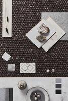 Stylish flat lay composition of architect moodboard with samples of building, brown textile and natural materials and personal accessories. Top view, template. photo