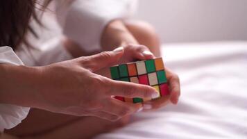 A woman engages in the intellectually stimulating and enjoyable hobby of solving a jigsaw cube puzzle. video