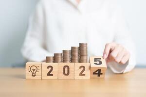 2024 end year to Happy New Year 2025 with Coins stack and lightbulb icon. Business Idea, Creative, Thinking, brainstorm,Money, Budget, investment, financial, savings and New Year Resolution concept photo