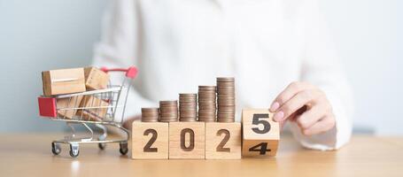 2024 end year to Happy New Year 2025 with shopping cart and money coins stack. online shopping, Marketplace platform website, technology, ecommerce, shipping delivery, logistics and online payment photo