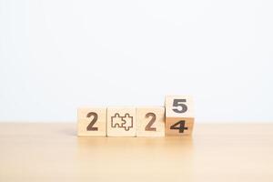 2024 year change to 2025 year block with jigsaw puzzle icon. Business Process, Team, teamwork, Goal, mission, Resolution, strategy, plan, Action, partnership, and New Year start photo