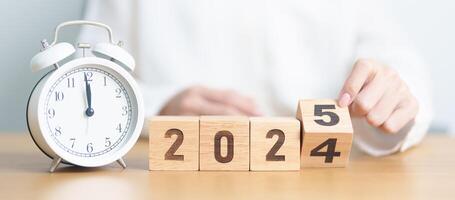 2024 end year to Happy New Year 2025 with vintage alarm clock. Christmas, New Start, Resolution, countdown, Goals, Plan, Action and Motivation Concept photo