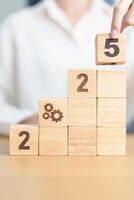 2025 year block with gear icon. Business Process, Team, teamwork, Goal, Target, Resolution, strategy, plan, Action, motivation, change, brainstorm and New Year start concepts photo