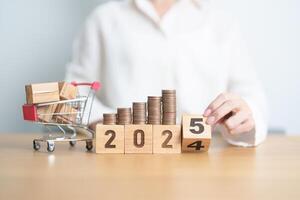 2024 end year to Happy New Year 2025 with shopping cart and money coins stack. online shopping, Marketplace platform website, technology, ecommerce, shipping delivery, logistics and online payment photo