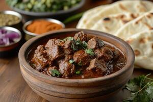 Spicy beef curry served in rustic bowl with cilantro garnish and naan bread photo