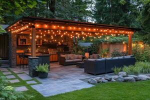Cozy backyard patio with string lights illuminating outdoor kitchen and lounge area photo