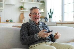 mayor hombre compras en línea participación teléfono inteligente pago con crédito tarjeta. antiguo abuelo comprando en Internet entrar crédito tarjeta detalles. en línea compras entrega Servicio más viejo Generacion moderno tecnología uso foto