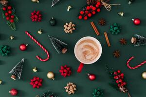 Christmas pattern made of winter and Xmas objects with hot drink on green background. Minimal creative Christmas and New Year concept. Festive holiday pattern backdrop. Christmas aesthetic. Flat lay. photo