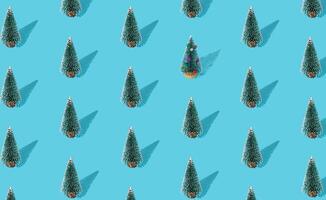 Christmas pattern composition made of green Xmas tree on blue background. Creative minimal Christmas and New Year concept. Festive winter holiday pattern backdrop. Christmas aesthetic background. photo