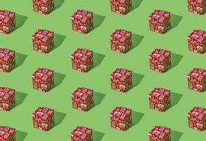 Trendy pattern composition made with red Christmas gift box on light green background. Minimal creative Christmas and New Year concept. Festive holiday pattern backdrop. Xmas aesthetic. photo