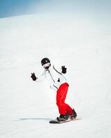 Front view young cool man snowboarding on the slopes of ski resort isolated in snowy day photo