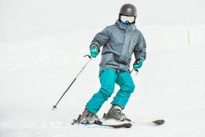 Young man learning to ski on a snowy slope close up front view isolated pose photo