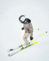Side view skier skiing downhill on piste white snow isolated in snowy conditions with low visibility photo