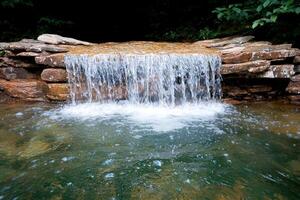 Serene waterfall in lush forest photo