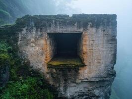 Mysterious cave entrance in misty mountain landscape photo