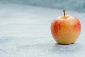 Crisp red apple on a textured surface photo