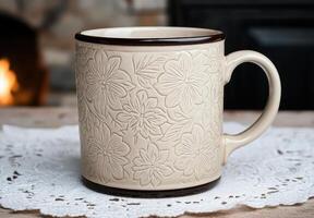 Embossed floral ceramic mug on lace doily photo