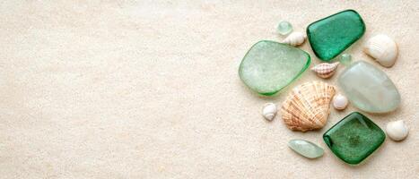 Assorted seashells and smooth stones on sandy beach photo