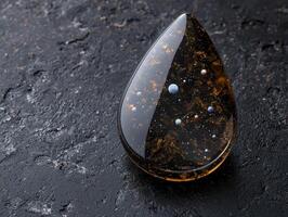 Cosmic glass teardrop with celestial elements photo