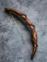 Twisted wooden bow on gray background photo