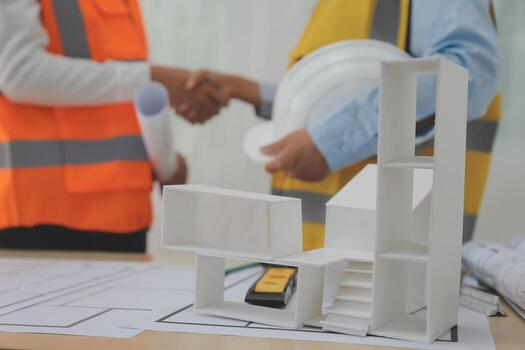 Construction and structure concept of Engineer or architect meeting for project working with partner and engineering tools on model building and blueprint in working site, contract for both companies. photo