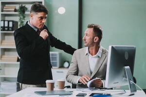 Two businessmen working together Analyze financial reports with charts and graphs while using the calculator to calculate budget, income, taxes, business growth. Startup business idea. photo