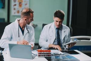Group of medical practitioners working together and analyzing medical scan in the hospital photo
