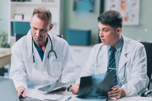 Group of medical practitioners working together and analyzing medical scan in the hospital photo