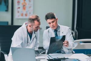Group of medical practitioners working together and analyzing medical scan in the hospital photo
