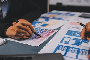 The designer team is designing the uxui system to make the uxui system work well on new phones and support system updates. Website development concept UI UX front end designer photo