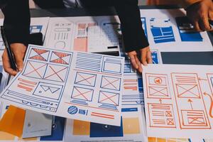 The designer team is designing the uxui system to make the uxui system work well on new phones and support system updates. Website development concept UI UX front end designer photo