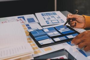 The designer team is designing the uxui system to make the uxui system work well on new phones and support system updates. Website development concept UI UX front end designer photo