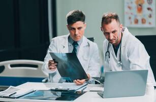 Group of medical practitioners working together and analyzing medical scan in the hospital photo