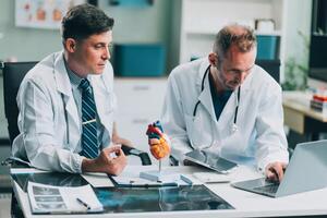 Group of medical practitioners working together and analyzing medical scan in the hospital photo