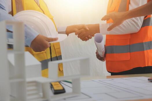 Construction and structure concept of Engineer or architect meeting for project working with partner and engineering tools on model building and blueprint in working site, contract for both companies. photo