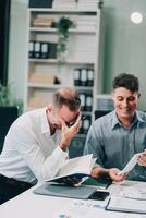Two businessmen working together Analyze financial reports with charts and graphs while using the calculator to calculate budget, income, taxes, business growth. Startup business idea. photo