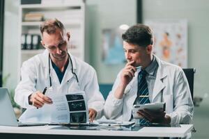 Group of medical practitioners working together and analyzing medical scan in the hospital photo