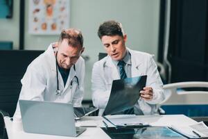 Group of medical practitioners working together and analyzing medical scan in the hospital photo