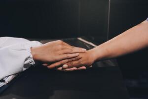 Kind male doctor wearing white coat consulting elder senior female patient holding hand of older woman giving help, safety, empathy and support, showing care and compassion concept. Close up view photo