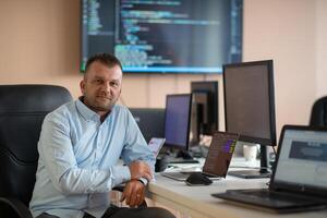 A programmer diligently testing smartphone applications while sitting in their office. photo